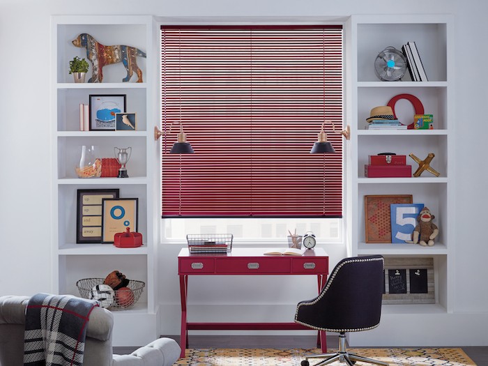 A home office with a red desk and red window blinds.